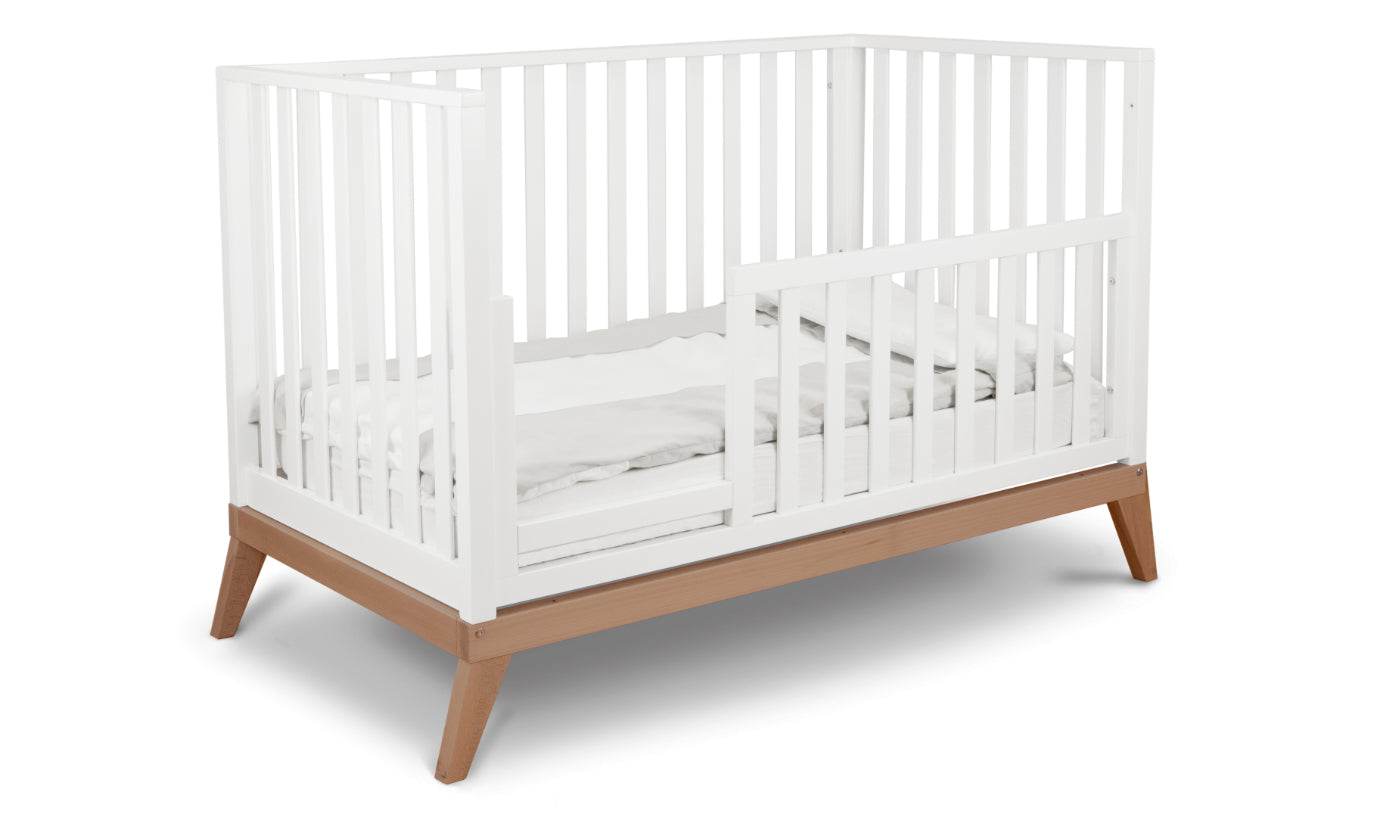 Donatello crib set up as a toddler bed, in white/walnut