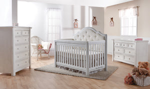 Cristallo Collection in vintage white. Crib with beige fabric headboard panel, seven drawer double dresser, and six drawer chest.