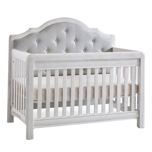 Cristallo Crib with grey vegan leather headboard panel, in vintage white finish.