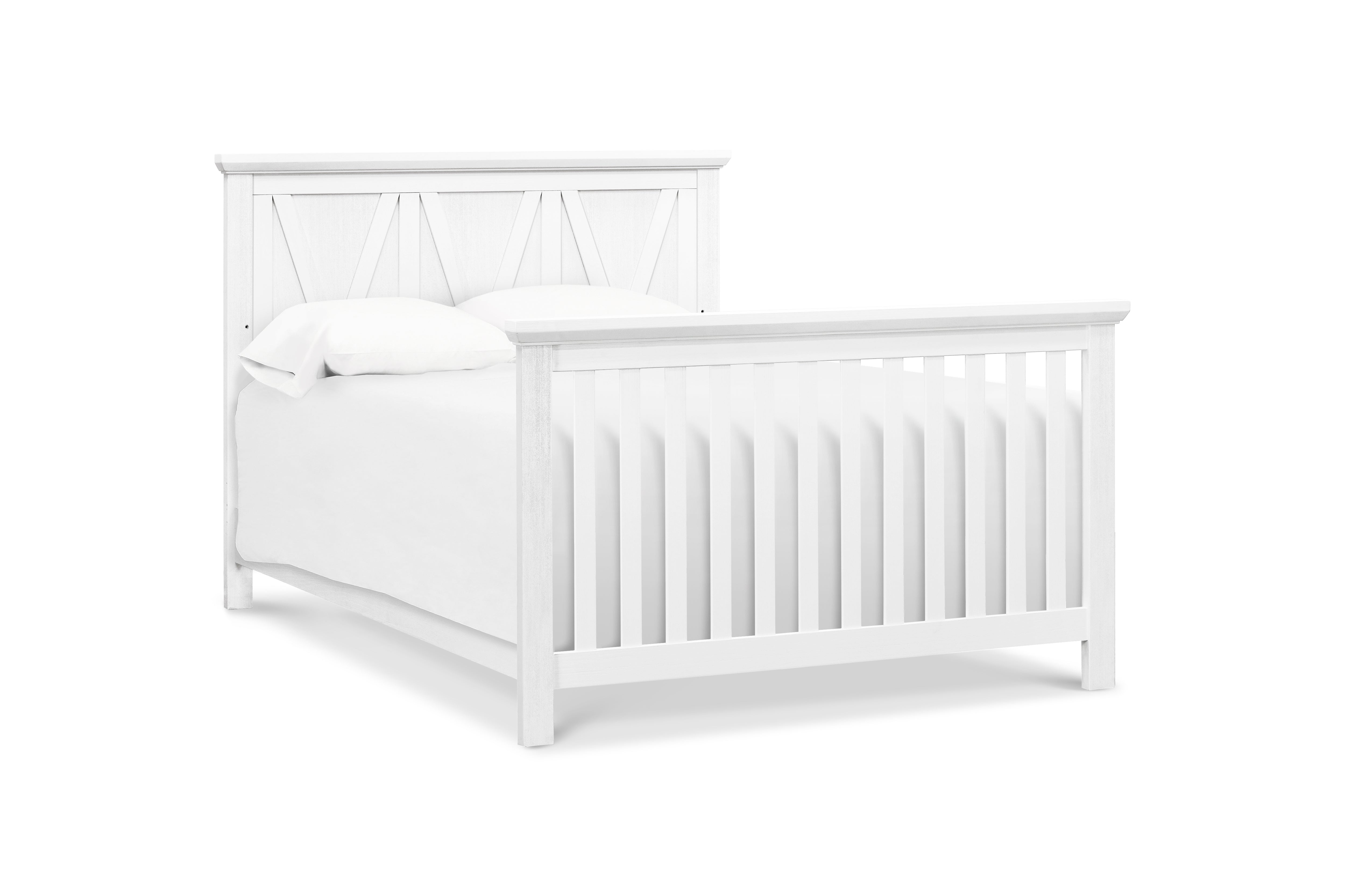 White crib converted to full size bed on a white background
