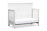 Load image into Gallery viewer, White crib set up as daybed with a simple design on a white background
