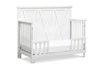 Load image into Gallery viewer, White crib set up as toddler bed with a cross-patterned design on a white background
