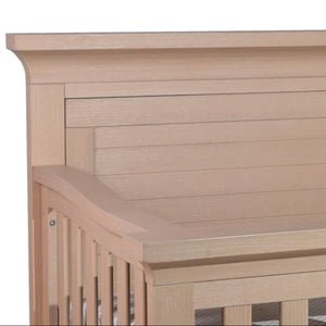 Wooden crib with slatted headboard.