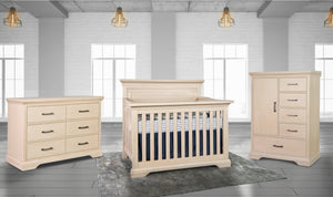 Beige nursery furniture set including a crib, dresser, and chest of drawers in a room with large windows.