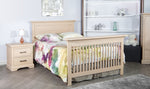 Load image into Gallery viewer, Sandstone crib converted to a full size bed with two drawer nightstand and white shelves.
