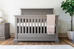 Load image into Gallery viewer, Ash crib with a white mattress and beige blanket in a room with a plant and nightstand.

