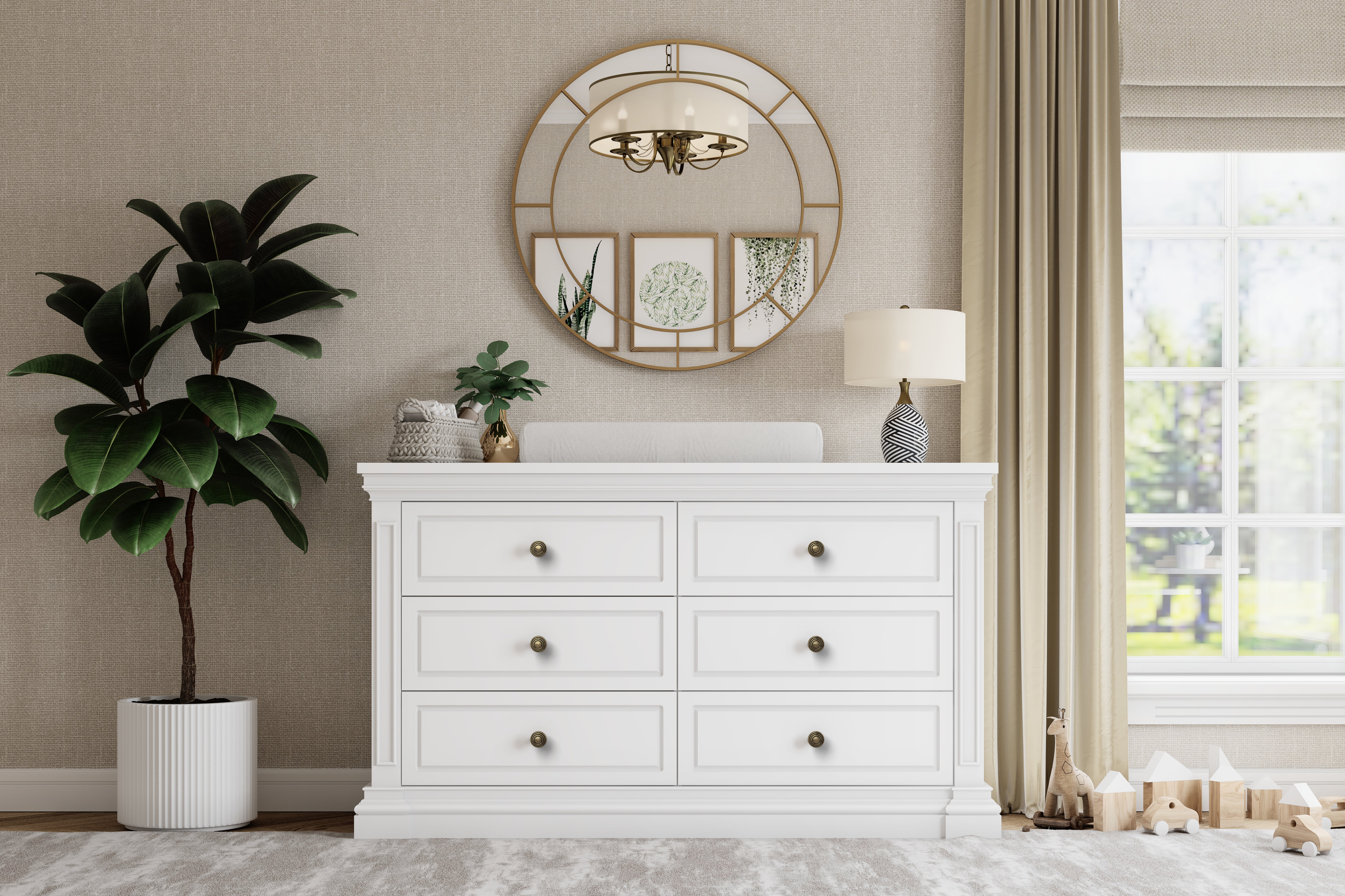 White dresser with decorative mirror and plants in a room with a window and curtains.
