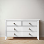 Load image into Gallery viewer, White dresser with six drawers and brass knobs on a wooden floor.
