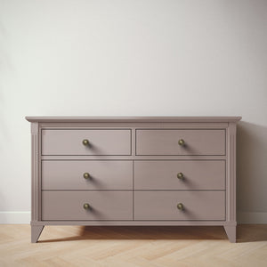 Wooden dresser with six drawers on a wooden floor against a white wall