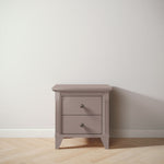 Load image into Gallery viewer, Small wooden nightstand with two drawers against a white wall.
