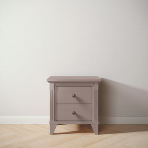 Small wooden nightstand with two drawers against a white wall.