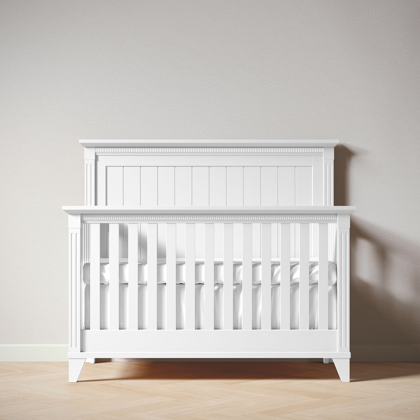White crib against a plain wall