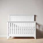 Load image into Gallery viewer, White crib against a plain wall

