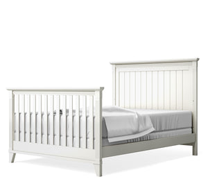White crib converted to full bed set on a white background