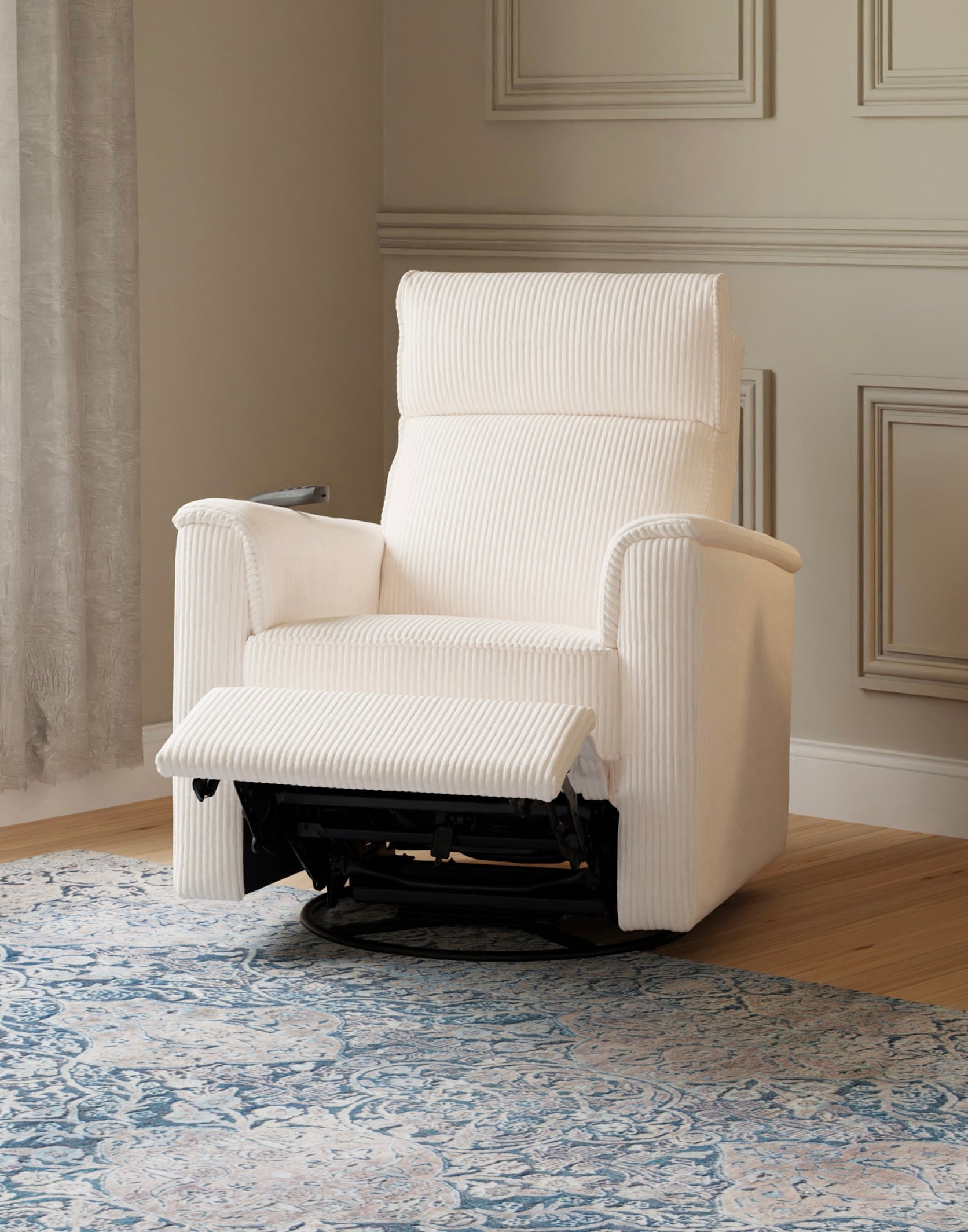 White recliner chair in a room with decorative wall paneling and a patterned rug.