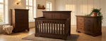 Load image into Gallery viewer, Wooden crib with matching dresser and chest in a room with large windows.
