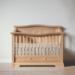 Load image into Gallery viewer, Wooden crib with a white mattress against a plain wall
