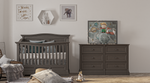 Load image into Gallery viewer, A styled nursery room featuring a dark gray wooden crib and matching dresser, decorated with framed wall art, pillows, and toys on a light wood floor.
