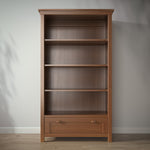 Load image into Gallery viewer, Wooden bookshelf with a drawer against a gray wall
