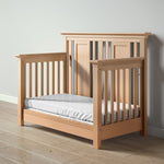 Load image into Gallery viewer, Karisma crib, converted to a day bed, with a mattress on a wooden floor against a white wall
