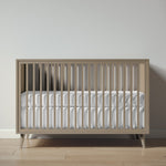 Load image into Gallery viewer, Wooden crib with white mattress against a plain wall
