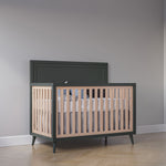Load image into Gallery viewer, Wooden crib with green frame and beige slats against a gray wall.
