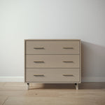 Load image into Gallery viewer, Wooden dresser with four drawers against a white wall.
